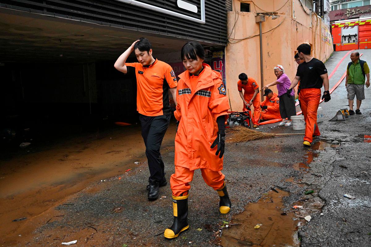 Rescue members pump out water from a parking lot after flooding caused by record-breaking rains in Seosan on July 17, 2025. Parts of South Korea were battered by torrential rains July 17, with one region pummelled by the most rainfall per hour since full records began in 1904, the country’s weather agency said. - Jung Yeon-je / AFP