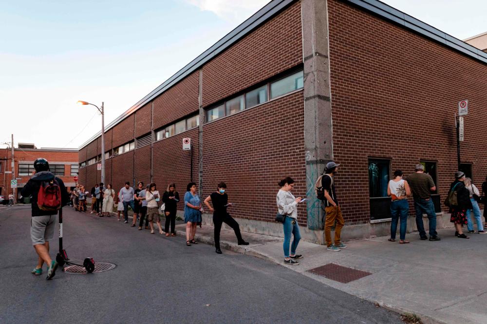 People wait in line to cast their ballots at Ecole Laurier on voting day in Montreal, Que. on Sept. 20, 2021/AFPPix