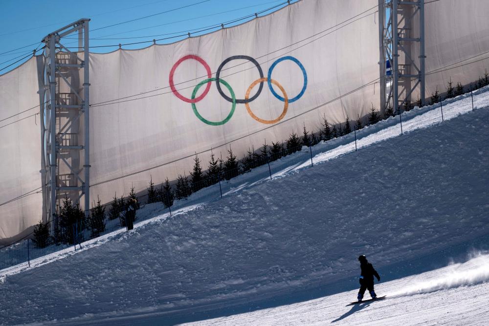 A coach takes part in a snowboarding slopestyle practice session at the Genting Snow Park in Zhangjiakou on February 2, 2022, ahead of the Beijing 2022 Winter Olympic Games. AFPPIX