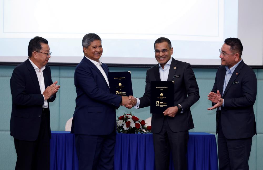 Mohammed Azman (second from right) and Saripuddin exchange MoUs at the signing ceremony between Socso and Mavcom today, witnessed by Socso deputy CEO operations Azirruan Arifin (right) and Mavcom aviation development director Jaffar Derus Ahmad. – Bernamapic