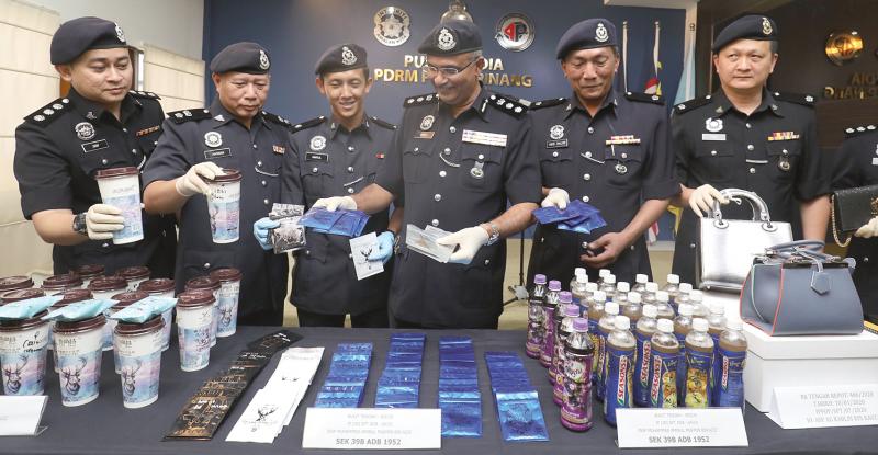 Maidu (4thL) shows drugs packed in tea sachets at the press conference.
