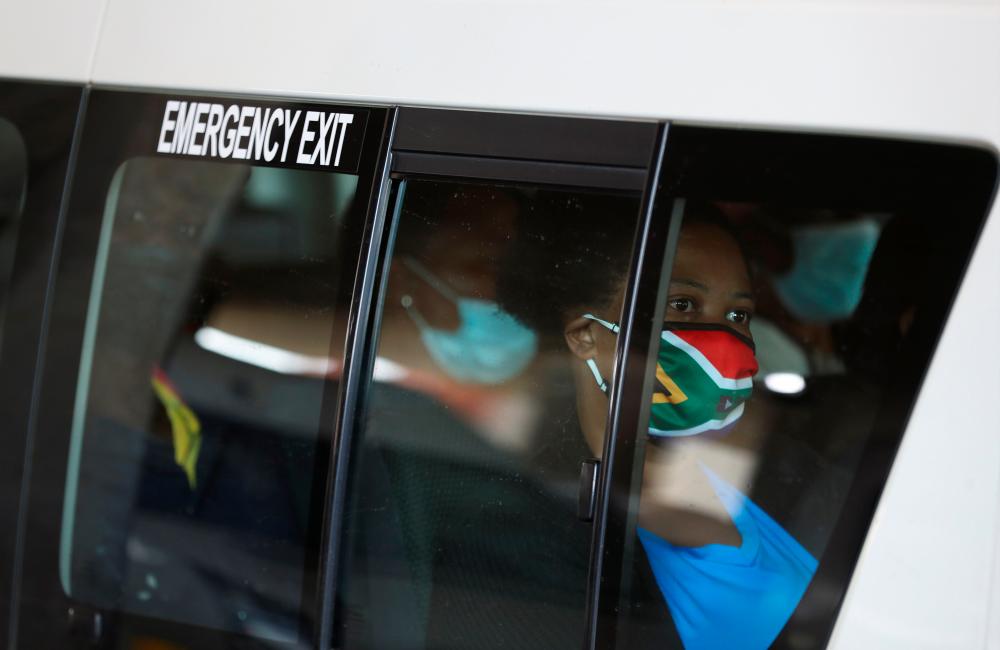 A passenger in a taxi wears a face mask with colours of the South African flag after the announcement of a British ban on flights from South Africa because of the detection of a new coronavirus disease (Covid-19) variant, in Soweto, South Africa, November 26, 2021. REUTERSpix