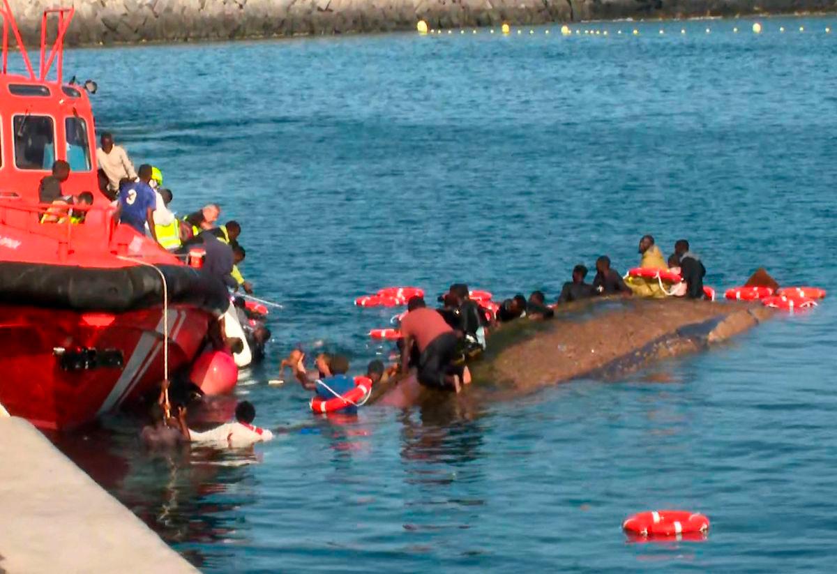 This grab from a handout video released by Television Canaria shows rescuers attempting to save people from drowning after migrants getting ready to disembark their overcrowded boat accidentally capsized the vessel, in the port of La Restinga on the island of El Hierro, Canary Islands, Spain, on May 28, 2025. AFPpix/TV Canaria