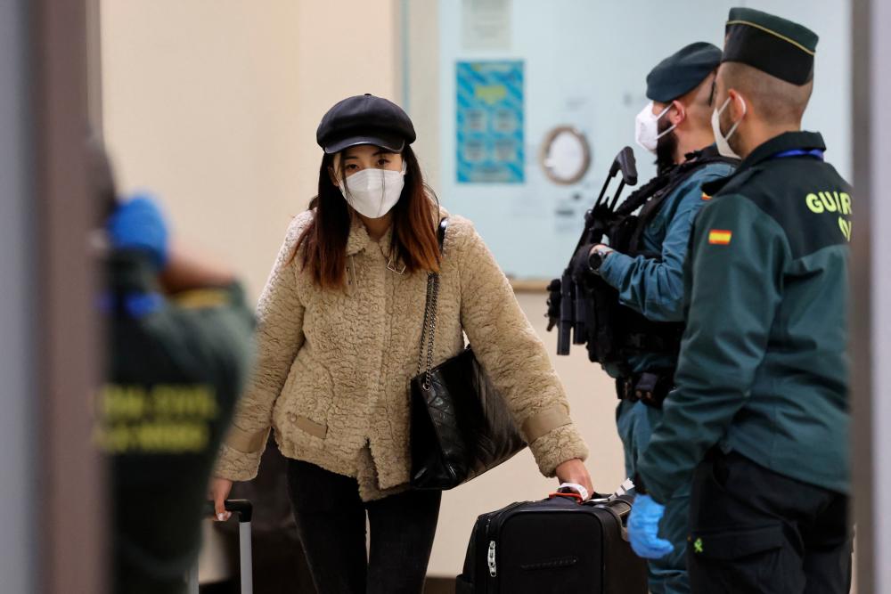 A passenger of a flight from Beijing leaves the terminal after landing at the Adolfo Suarez Madrid-Barajas airport in Barajas, on the outskirts of Madrid, on December 31, 2022/AFPPix