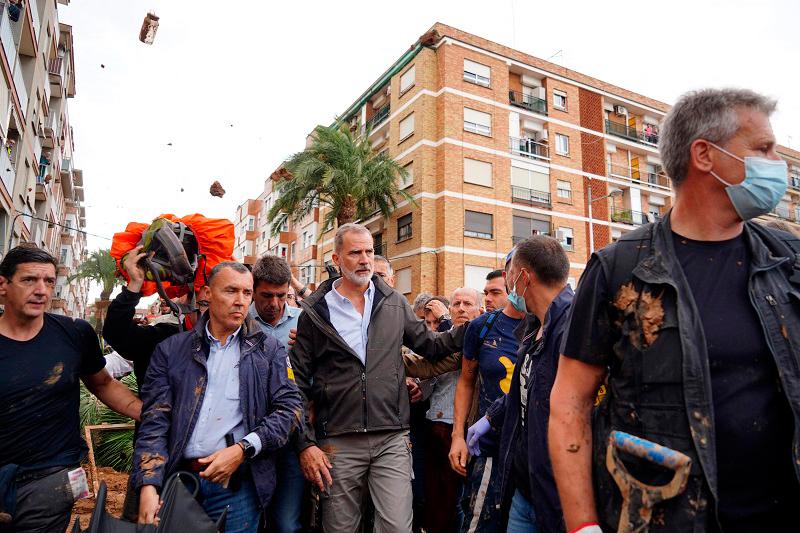 King Felipe VI of Spain (C) is heckled by angry residents who throw mud and objects during his visit to Paiporta, in the region of Valencia, eastern Spain, on November 3, 2024, in the aftermath of devastating deadly floods. - Manaure Quintero / AFPpix