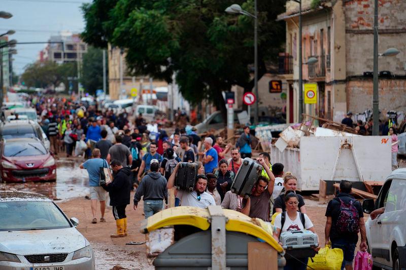 Residents walk in the street while transporting belongings following deadly flash floods in La Torre, south of Valencia, eastern Spain, on October 31, 2024. - AFPPIX