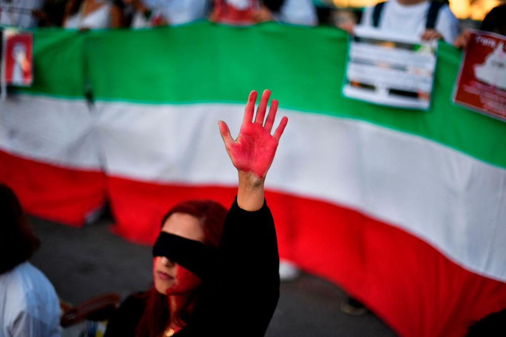 A woman raises her hand with red paint during a demonstration in support of Iranian women on October 4, 2022 in Barcelona following the death of Kurdish Iranian woman Mahsa Amini in Iran. AFPPIX