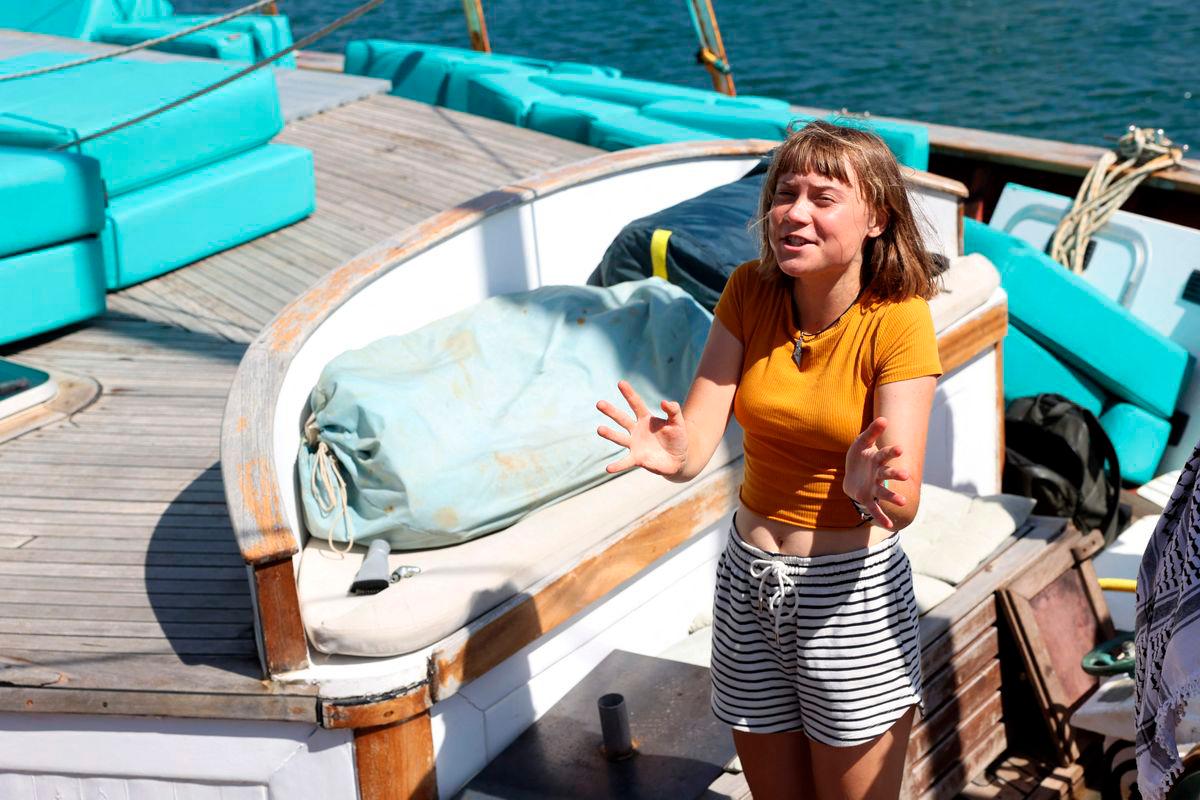 Swedish climate activist Greta Thunberg gestures onboard a boat as a flotilla carrying humanitarian aid and activists prepare to leave for Gaza, in Barcelona on August 30, 2025. A flotilla carrying humanitarian aid and activists, including Swedish climate campaigner Greta Thunberg, is set to depart Barcelona on August 31 to try to “break the illegal siege of Gaza,“ organizers said. (Photo by LLUIS GENE / AFP)