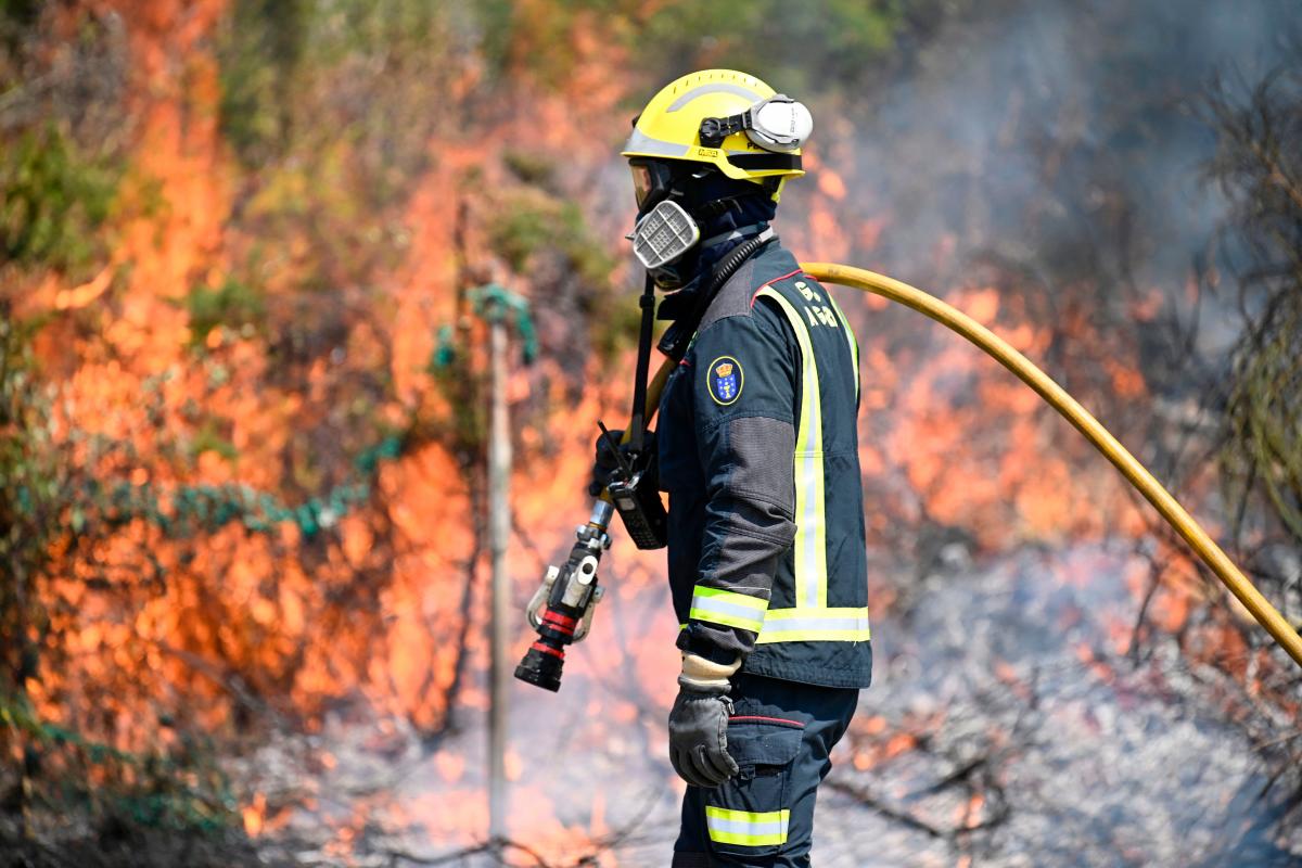 A firefighter works to control a wildfire near the village of Mougas, in Oia municipality, northwestern Spain on August 22, 2025. (Photo by MIGUEL RIOPA / AFP)