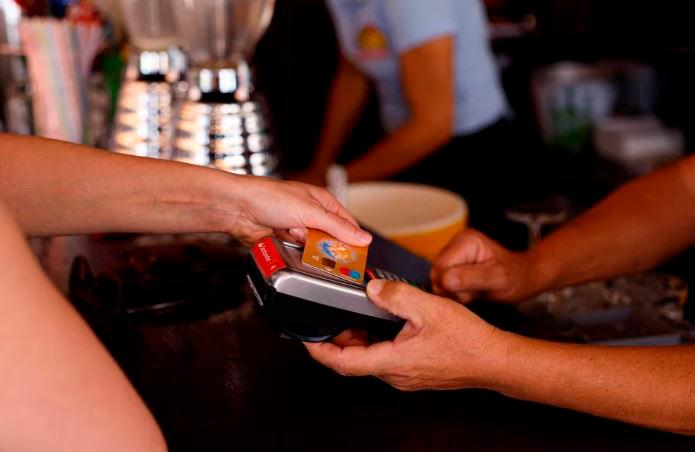 A woman pays with a credit card at a restaurant in Playa del Ingles, Maspalomas on the island of Gran Canaria, Spain, May 3, 2022. REUTERSPIX