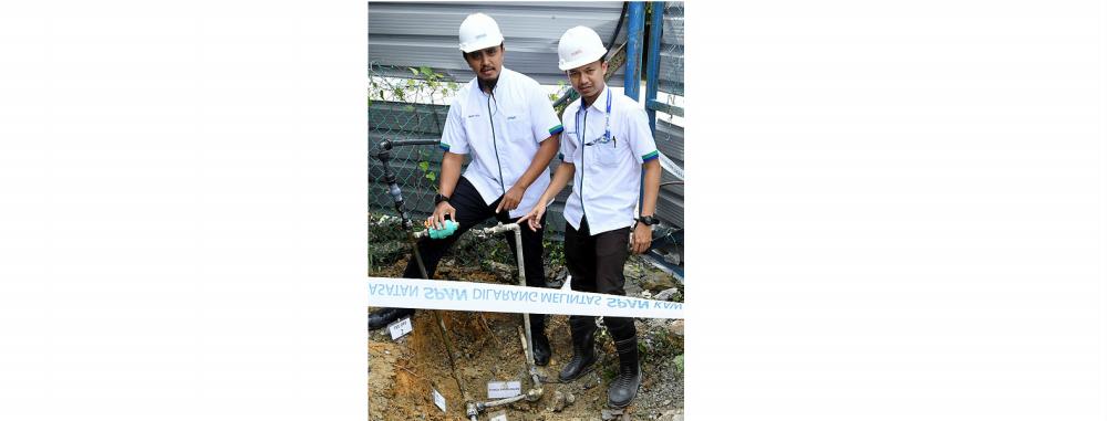 Span Corporate Communication and Consumer Affairs Director Mohd Fazil Ismail (left) shows an illegal water connection at a cement mixing premises in Seremban today.