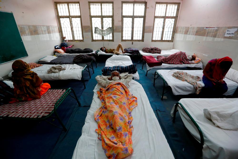 Migrant workers and their families rest in a room at a government-run temporary shelter at a school, during a 21-day nationwide lockdown to limit the spread of the coronavirus disease (Covid-19), in New Delhi, India, March 31, 2020. - Reuters