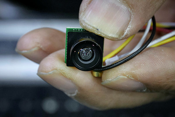 Electrical component vendor and technician Lee Seung-yon holds a mini camera unit capabale of being built into custom-made devices, at his store in a market in Seoul. — AFP