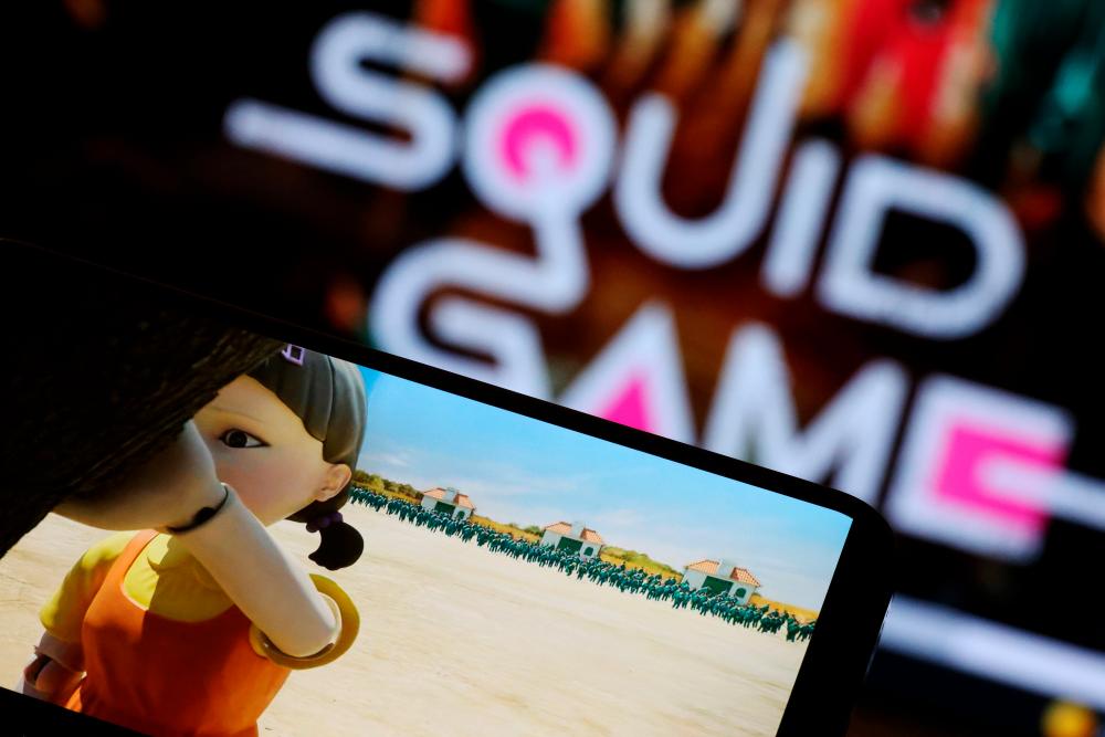 FILE PHOTO: The Netflix series Squid Game is played on a mobile phone in this picture illustration taken September 30, 2021. REUTERSpix