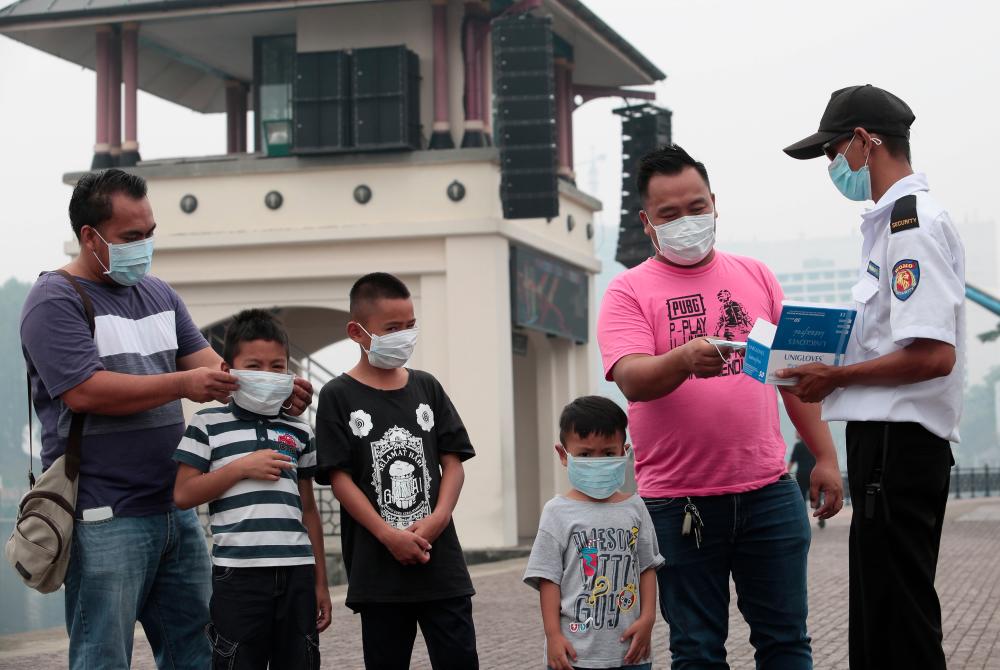 Safety Officer, Joewandy Bujang, 38, distributing masks for free to tourists in Kuching Waterfront area at 12 noon today. — BBXpress