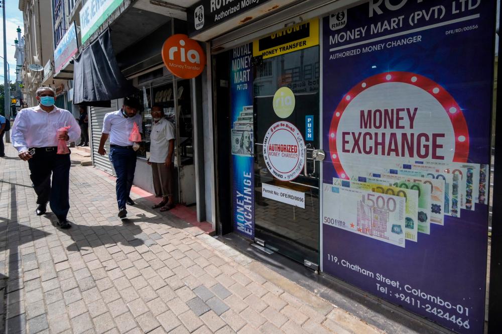 Pedestrians passing a currency exchange shop in Colombo on Monday, March 20, 2023. Cash-strapped Sri Lanka is seeking a 10-year moratorium on its foreign debt – AFPpic
