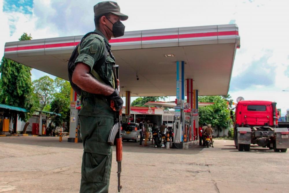 A member of Sri Lankan security personnel stands guard at a Ceylon Petroleum Corporation fuel station in Colombo on June 19. AFPpix