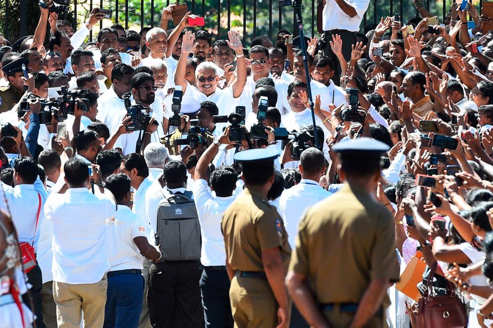Sri Lanka's new president Gotabhaya Rajapakse (C) gestures to his supporters upon his arrival at the Temple of the Sacred Tooth Relic in Kandy on November 20, 2019. - AFP