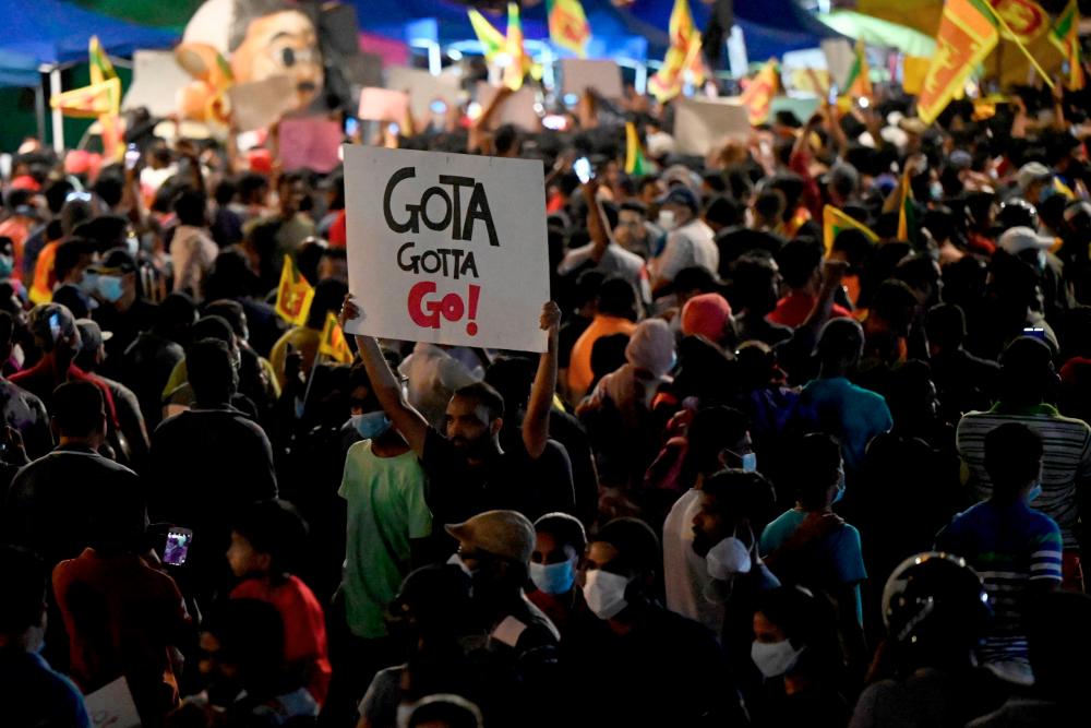 Protestors take part in a demonstration against the economic crisis at the entrance of the president's office in Colombo on April 13, 2022. - AFPPIX