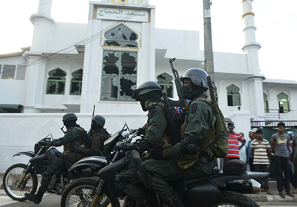 Heavily-armed Sri Lankan soldiers ride a motorcycle in front of the Jumha Mosque after a mob attack in Minuwangida on May 14, 2019. - AFP