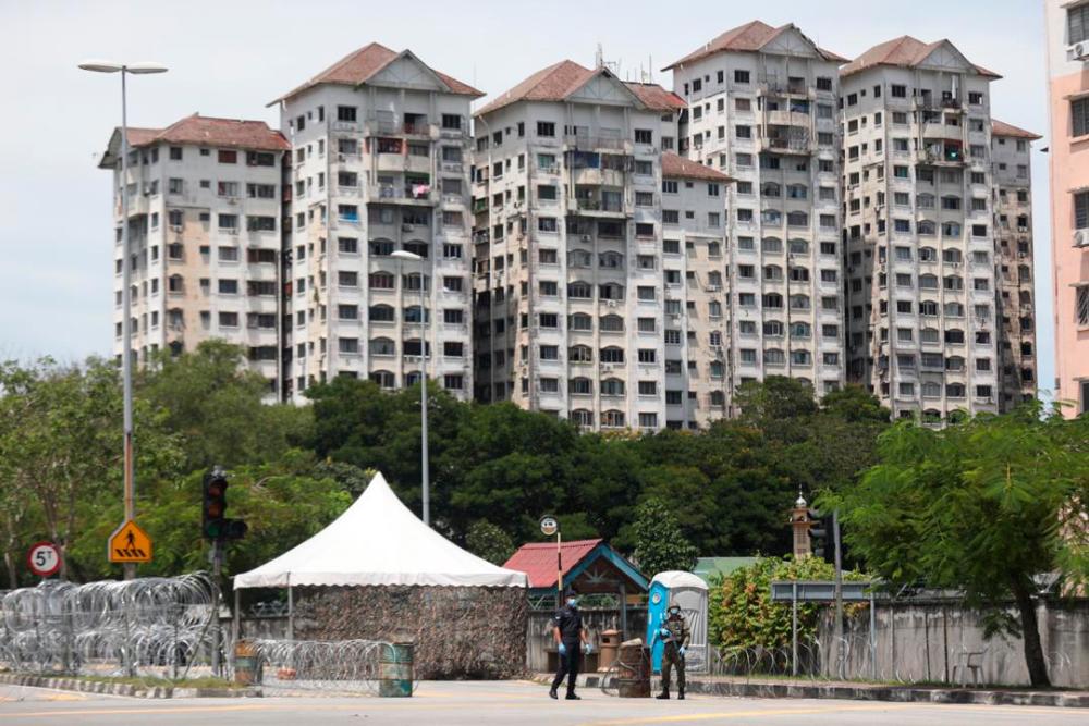 Officers from the Royal Malaysian Police and the Malaysian Armed Forces keep a watchful eye on the Sri Murni Apartments Fasa 2 in Selayang, on April 24, 2020. — Sunpix by Hafiz Sohaimi