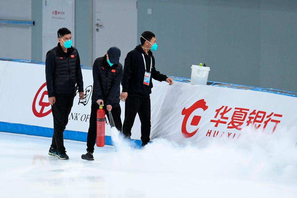 Staff members spray the track during the Speed Skating China Open, part of the 2022 Beijing Winter Olympic Games test event, at the National Speed Skating Oval in Beijing on October 10, 2021. AFPpix
