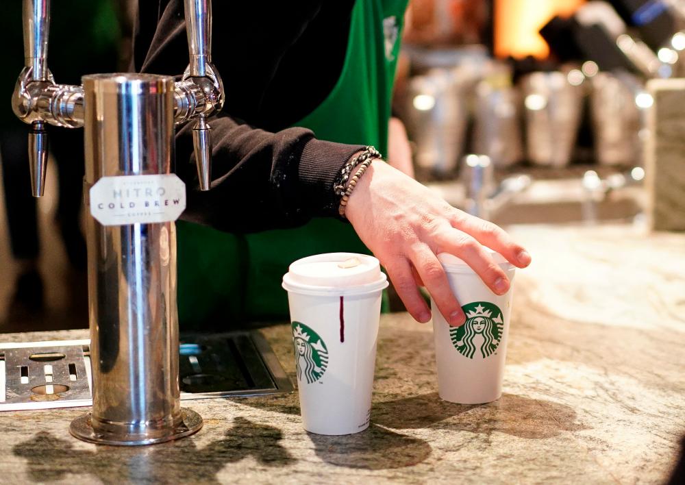File photo: A barista serves beverages in single-use cups inside a Starbucks in London, Britain, March 6, 2020. REUTERSpix