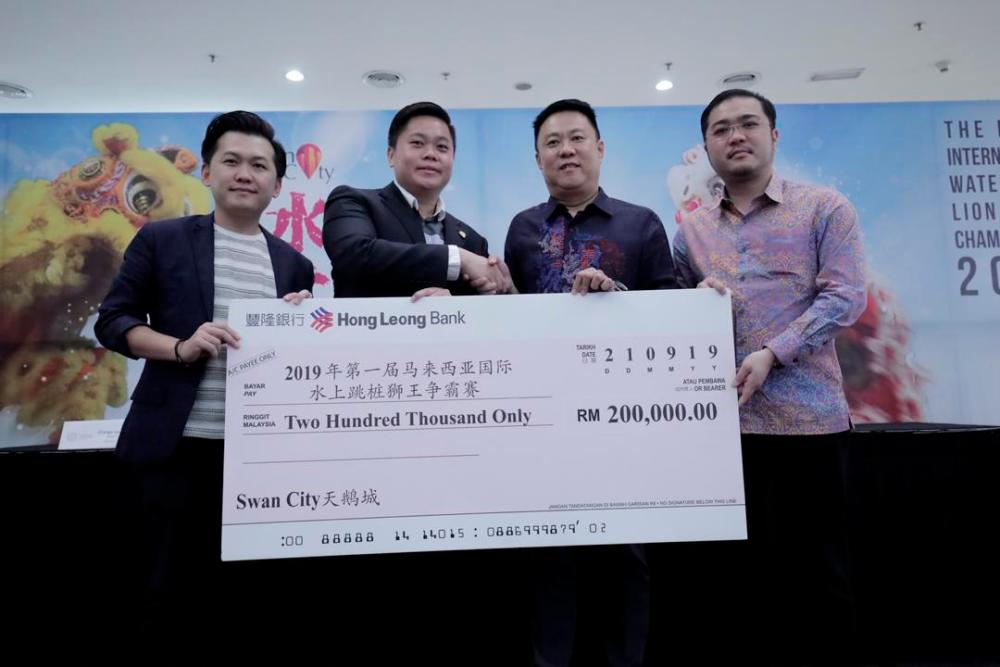 From left: Swan City head of event Low Hwang Hua and Swan City Head of Product Management Edwin Fuam presenting a mock cheque to Organising Chairman Datuk Wong Ying Sing. With them is president of Qi Ling Dragon and Lion Dance Association Datuk Seri Ly Kim Cheong. — Sunpix by Ashraf Shamsul