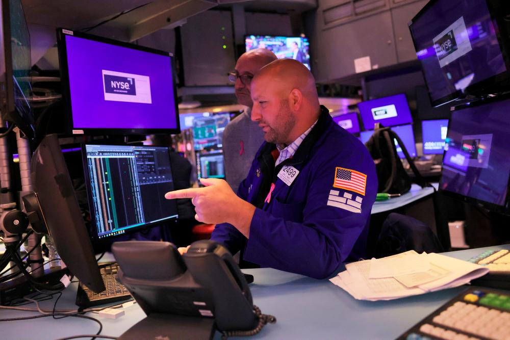 Traders work on the floor of the New York Stock Exchange during afternoon trading on Monday, Oct 3. US stocks started the fourth quarter of the year on a positive note. – AFPpix
