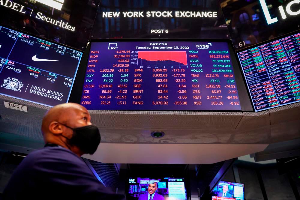 A trader stands beneath a screen on the trading floor at the New York Stock Exchange on Tuesday. – Reuterspix