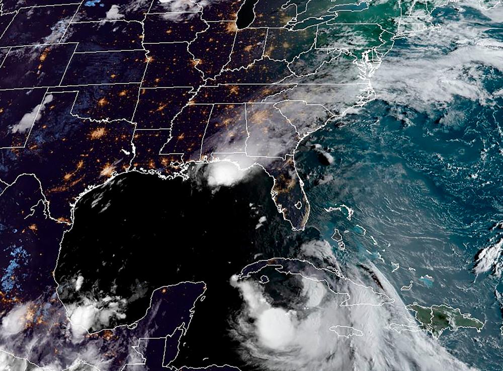 A satellite image obtained yesterday shows Tropical Storm Laura moving west-northwestward south of Cuba and Hurricane Marco in the US Gulf Coast (above). – AFPPIX