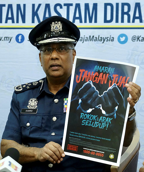Customs director-general Datuk Seri T. Subromaniam presents a campaign poster at a press conference on the implementation of amendments to the Customs Act 1967 and Excise Act 1976. — Bernama