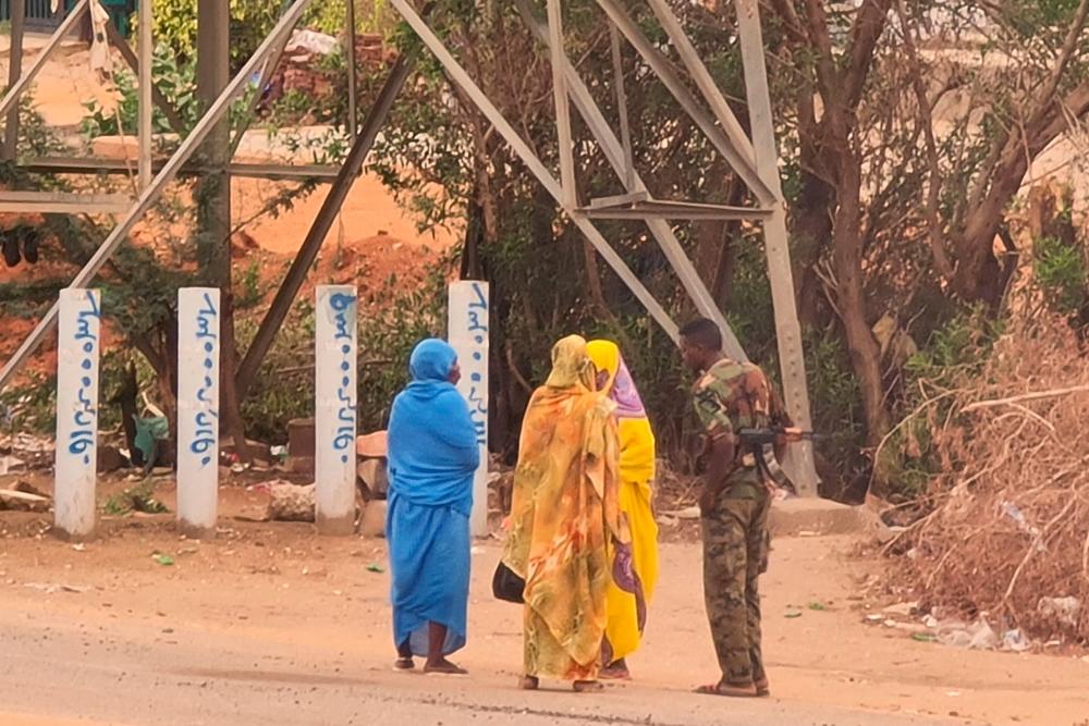 An army soldier talks to women on a street in Khartoum on June 6, 2023, as fighting continues in war-torn Sudan. AFPPIX