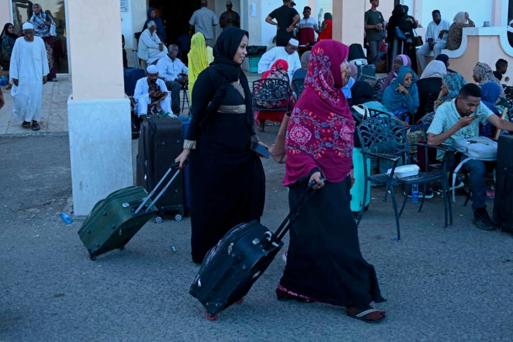 People wait with their luggage at Port Sudan on May 3, 2023 ahead of their evacuation by sea amid ongoing deadly clashes between rival generals' forces. - AFPPIX