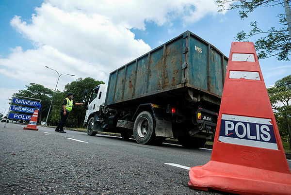 Polis officers spot-checking vehicles in and out the polluted areas of Sungai Kim Kim — Bernama