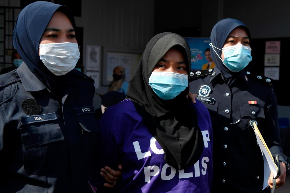 Siti Nur Athirah, who was clad in the purple police lock-up uniform, looked calm when she arrived at the court at 9.36am, — Bernama