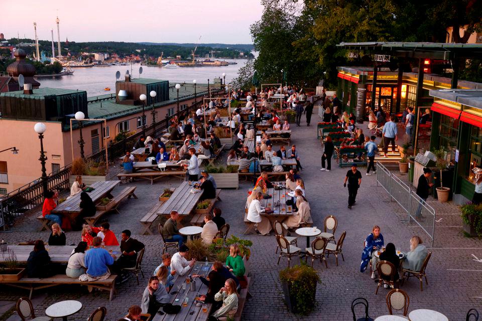 People sit at tables at an outdoor bar in Stockholm, Sweden, July 1 2021. Stefan Jerrevang/TT News Agency/via REUTERSpix