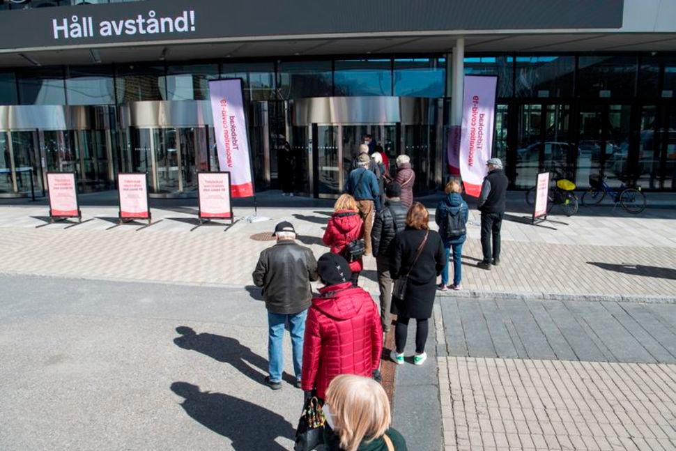 FILE PHOTO: People stand in line to get a vaccine against the coronavirus disease (Covid-19) outside the Stockholmsmassan exhibition center, turned mass vaccination centre, in Stockholm, Sweden, April 8, 2021. Fredrik Sandberg/TT News Agency — Reuters