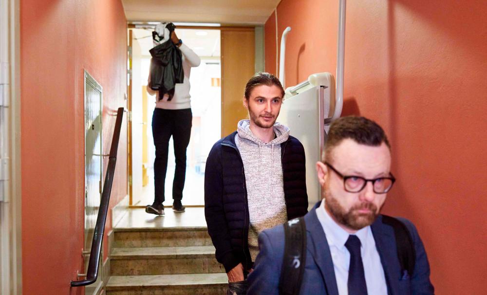 Picture taken on May 18, 2021 shows Swedish football player Pawel Cibicki (C) as he arrives at Malmo Court in Malmo, Sweden. Cibicki was convicted by a Swedish court on December 15, 2021 for having accepted bribes in a match fixing scandal. AFPPIX