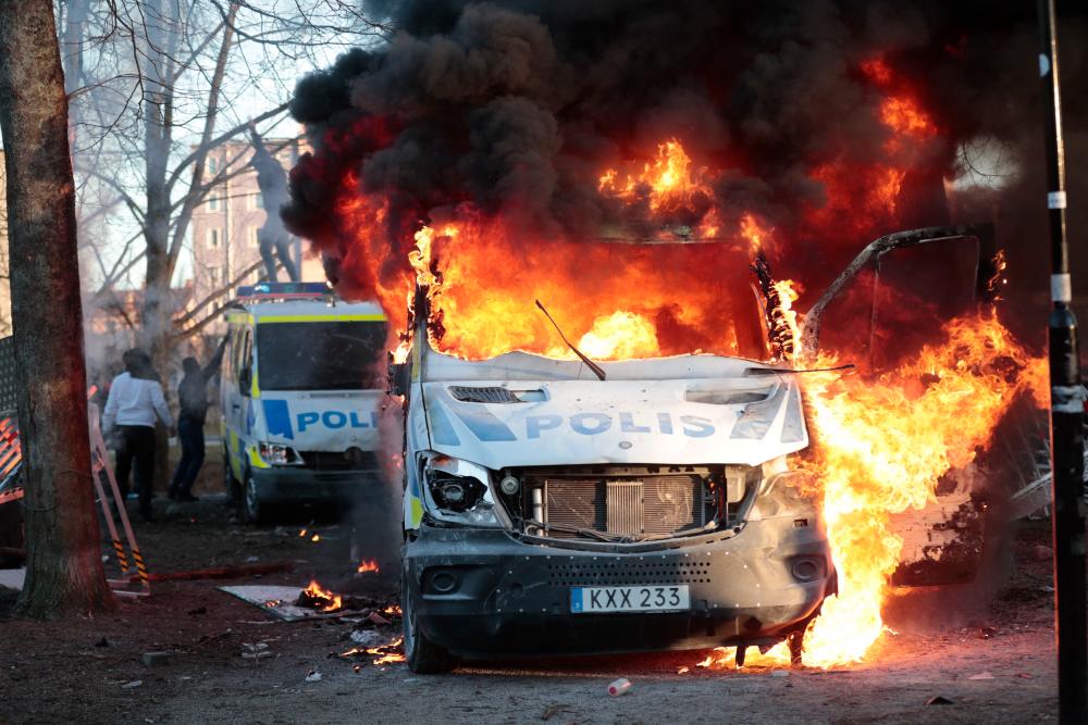 Police vans are on fire during a counter-protest in the park Sveaparken in Orebro, south-centre Sweden on April 15, 2022, where Danish far-right party Stram Kurs had permission for a square meeting on Good Friday. AFPpix