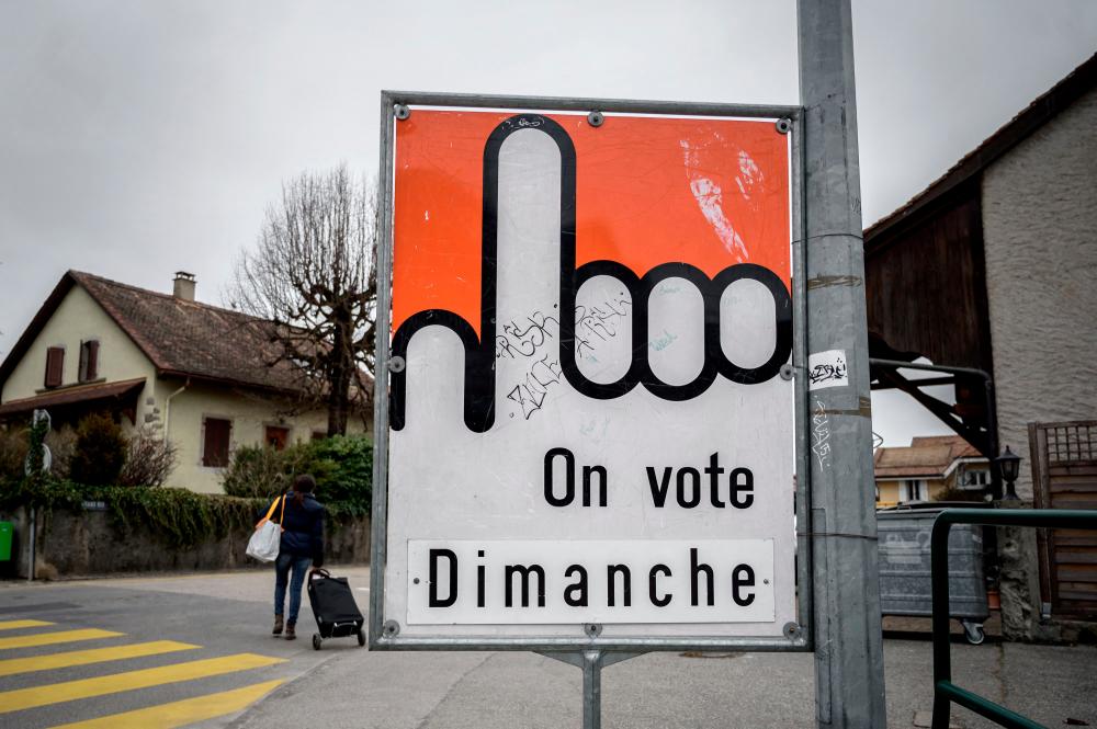 This photograph taken on March 6, 2021 in Gland shows a placard reading “We vote on Sunday” ahead of a nationwide vote by Swiss citizen on March 7, 2021 on whether to ban full facial coverings in public places, despite women in Islamic full-face veils being an exceptionally rare sight in Swiss streets. -AFP