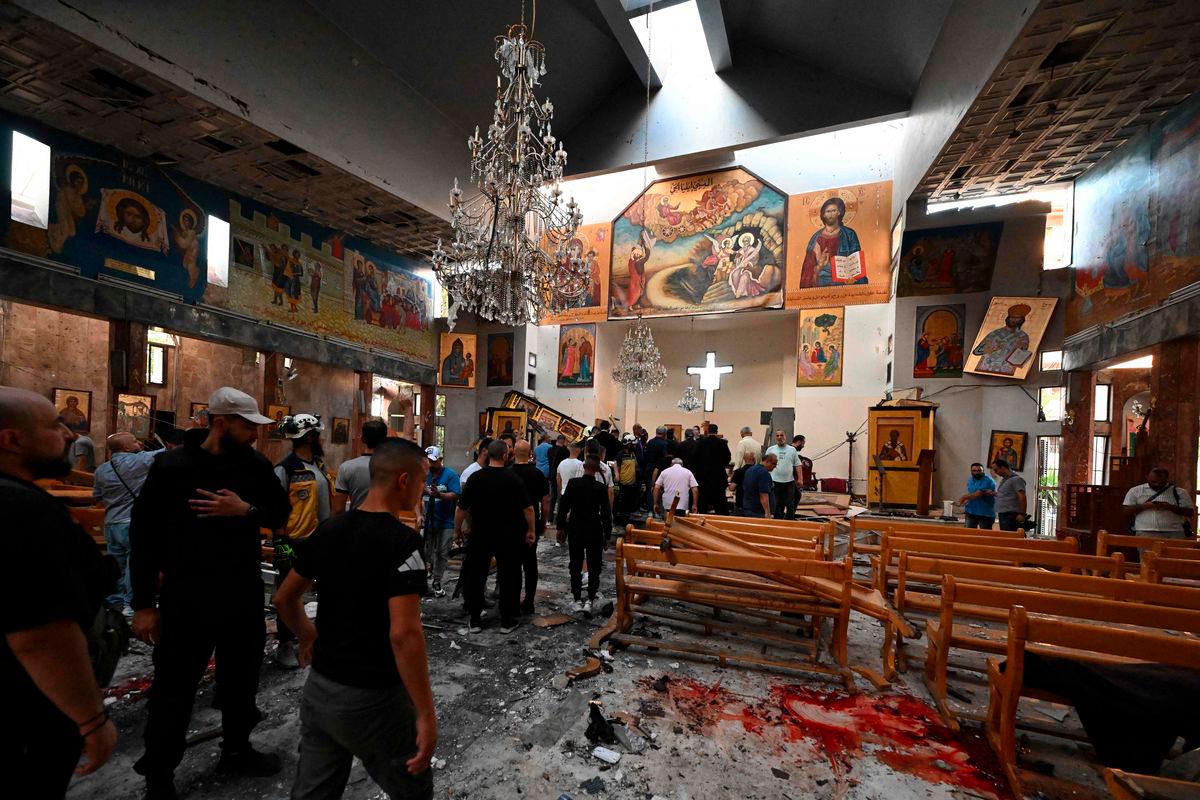 People and rescuers inspect the damage at the site of a reported suicide attack at the Saint Elias church in Damascus’ Dwelaa area on June 22, 2025. (Photo by LOUAI BESHARA / AFP)
