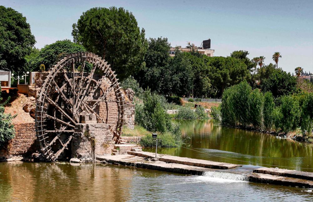 This picture taken on June 24, 2020 shows a view of the Kilanieh Noria (water wheel) along the Orontes (Assi) river in the city of Hama in west-central Syria. / AFP / LOUAI BESHARA