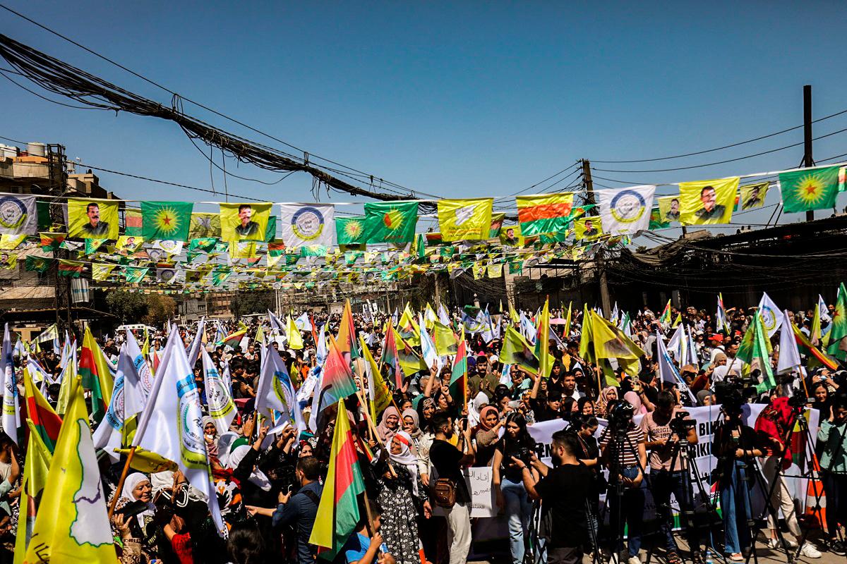 Syrian Kurds lift placards and flags during a rally calling for an autonomous administration and Kurdish rights in Syria’s predominantly-Kurdish northeastern city of Qamishli on September 17, 2025. - Delil SOULEIMAN / AFP