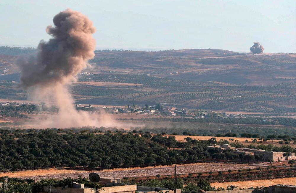 Smoke billows following reported regime air strikes on the village of Kafr Sajna in the southern outskirts of Syria’s Idlib province on August 16, 2019. — AFP