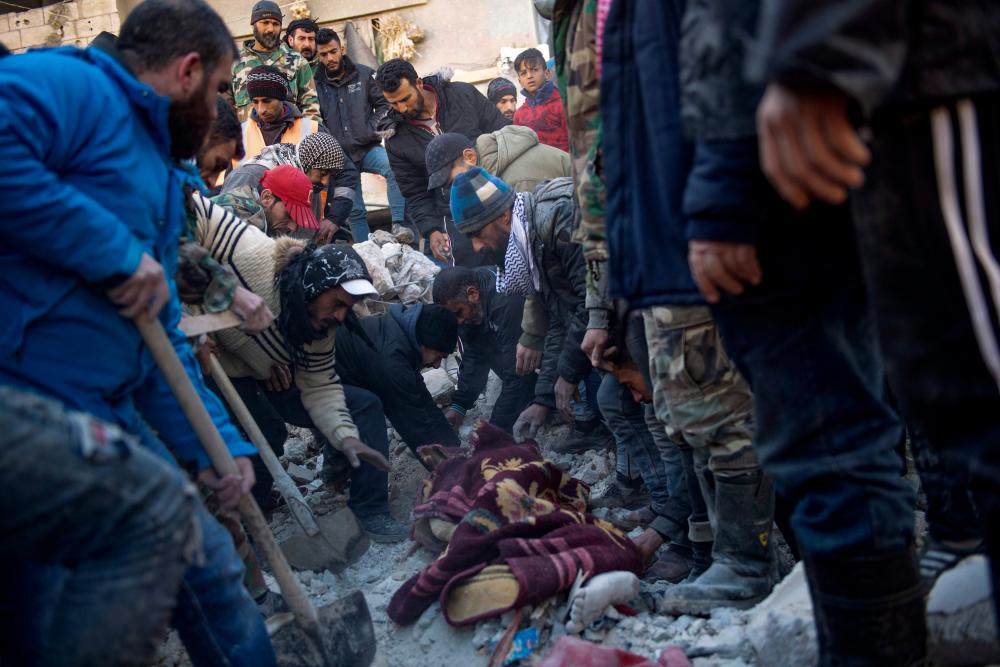 Residents retrieve a body from the rubble of a collapsed building in the regime-controlled town of Jableh in the province of Latakia, northwest of the capital Damscus, on February 8, 2023, two days after a deadly earthquake in Turkey and Syria. AFPPIX