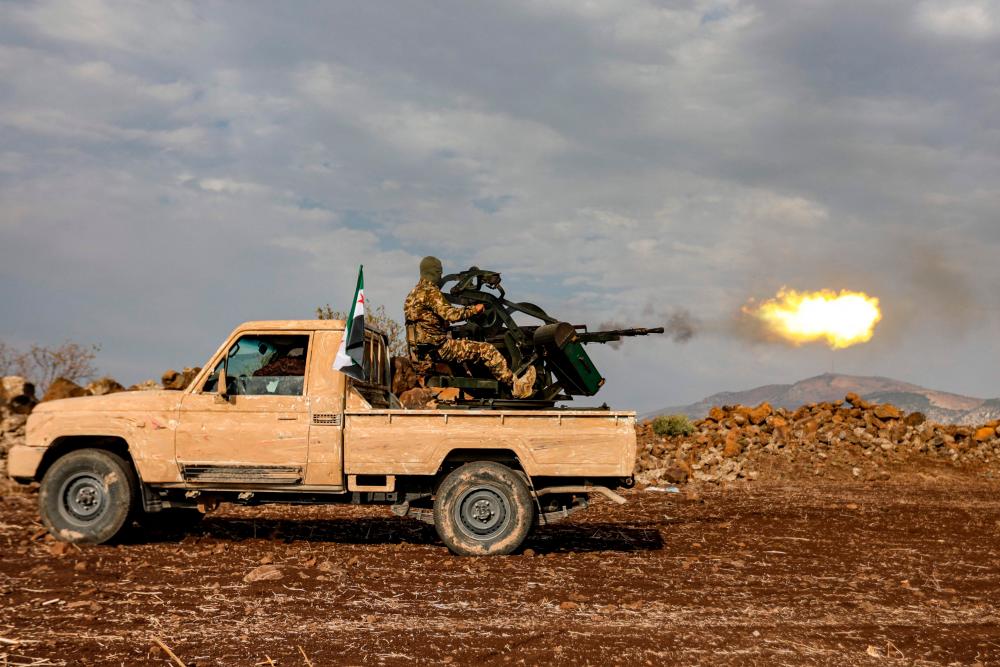 A Syrian fighter fires a turret in the back of a “technical” vehicle during military drills by the Turkish-backed “Suleiman Shah Division” in the opposition-held Afrin region of northern Syria on November 22, 2022. AFPPIX