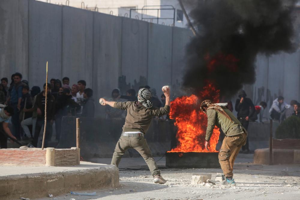 Syrian protesters hurl stones amid clashes with Turkish forces following a demonstration against Turkey's presence in northern Syria on Nov 17 in the town of al-Bab in Syria's northern Aleppo governorate. — AFP