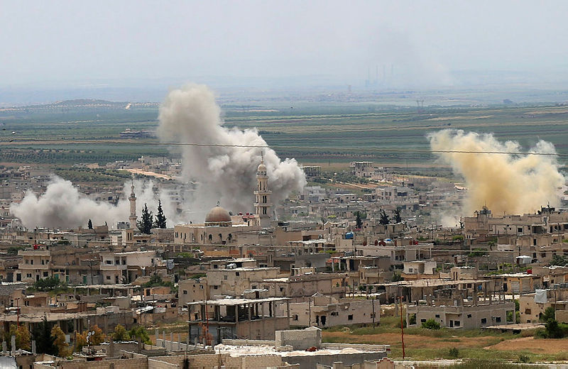 Smoke rises above buildings during shelling by Syrian regime forces and their allies on the town of Khan Sheikhun in the southern countryside of the rebel-held Idlib province on May 11, 2019. — AFP