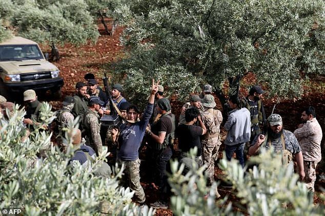 Syrian rebels gather in a field in the northern countryside of Hama province during clashes with regime forces. — AFP
